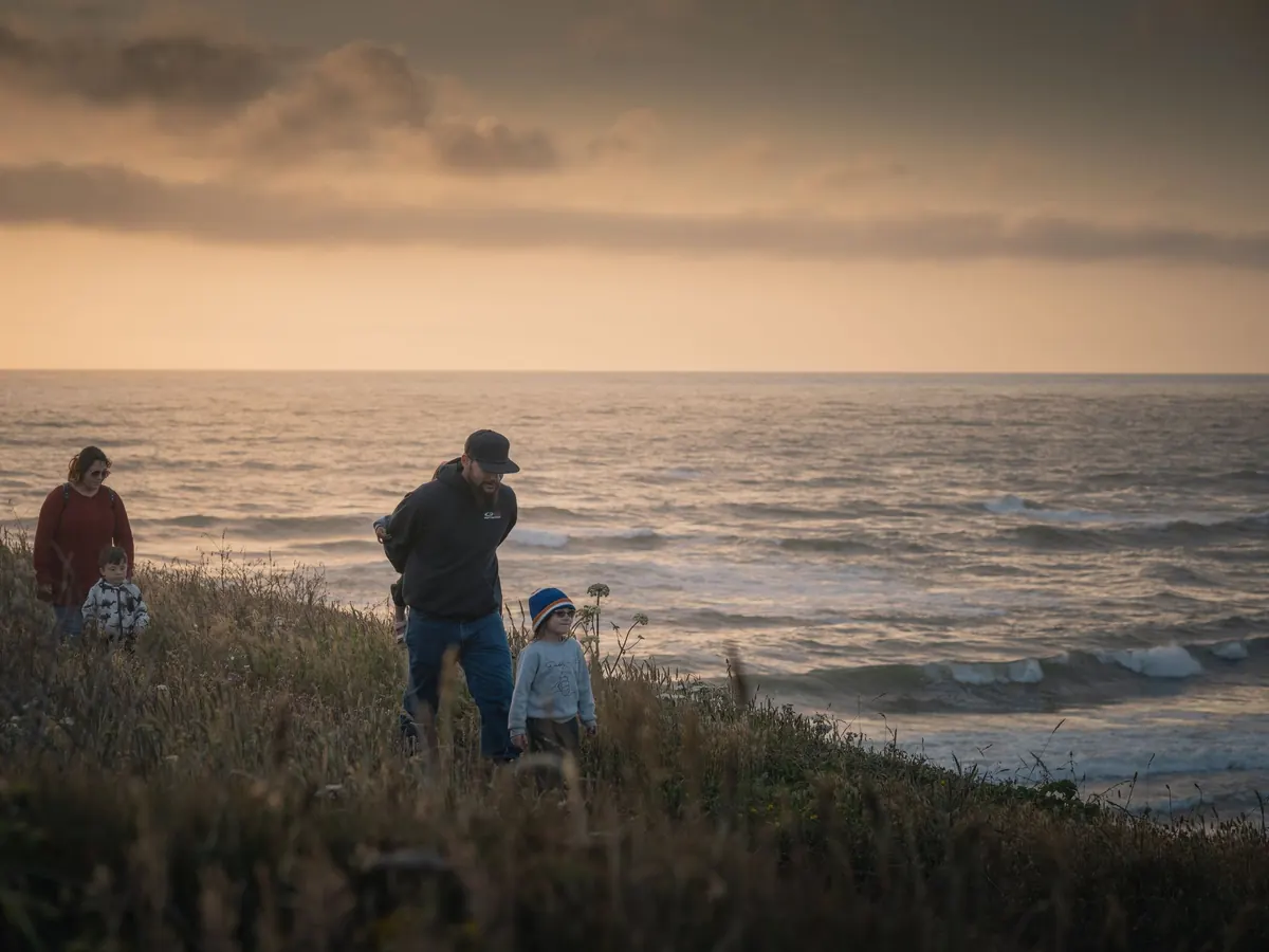 Familia mirando el mar al atardecer