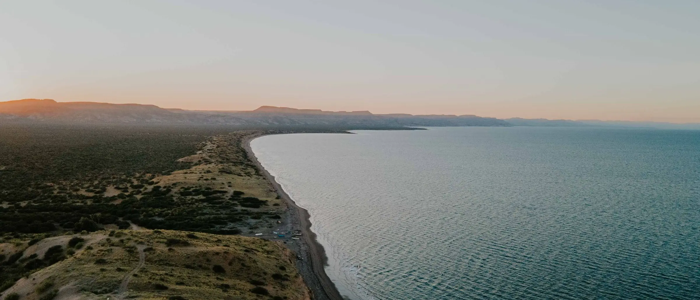 Vista aérea de la costa de Baja California con lomas y mar al atardecer