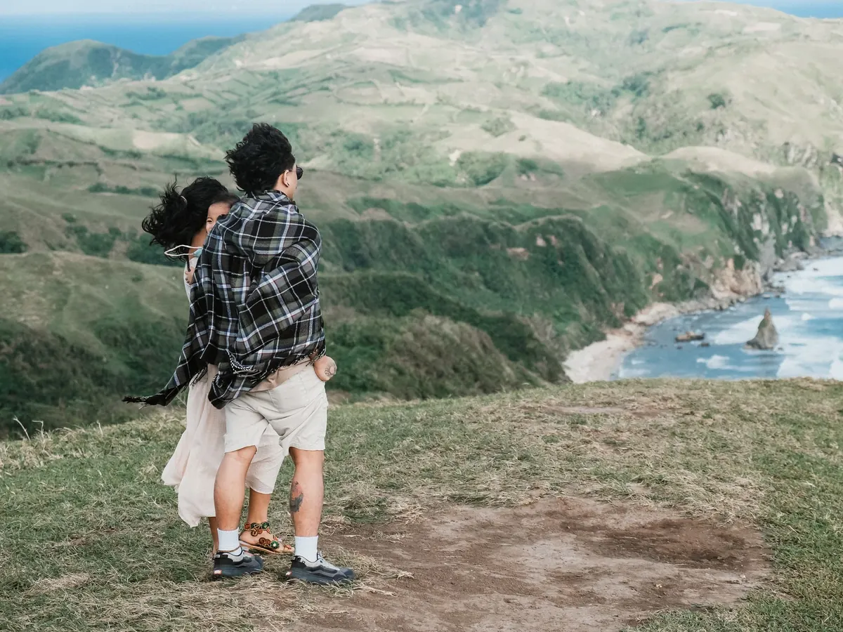 Pareja mirando la costa desde una loma