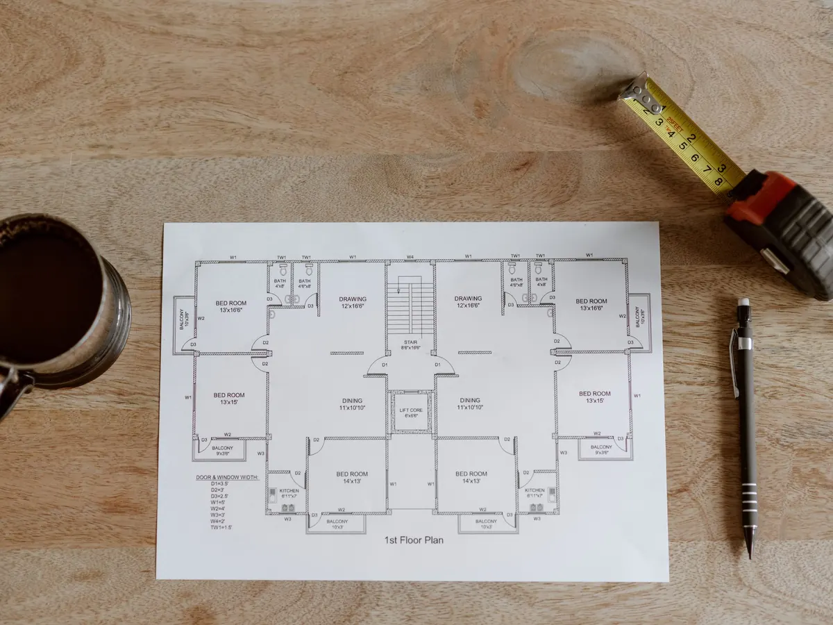 Plano arquitectónico con cinta métrica sobre una mesa